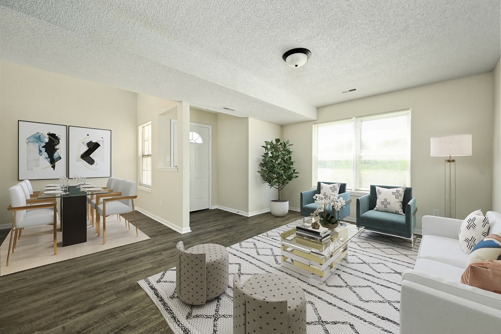 an open living room and dining room with white walls and a large window