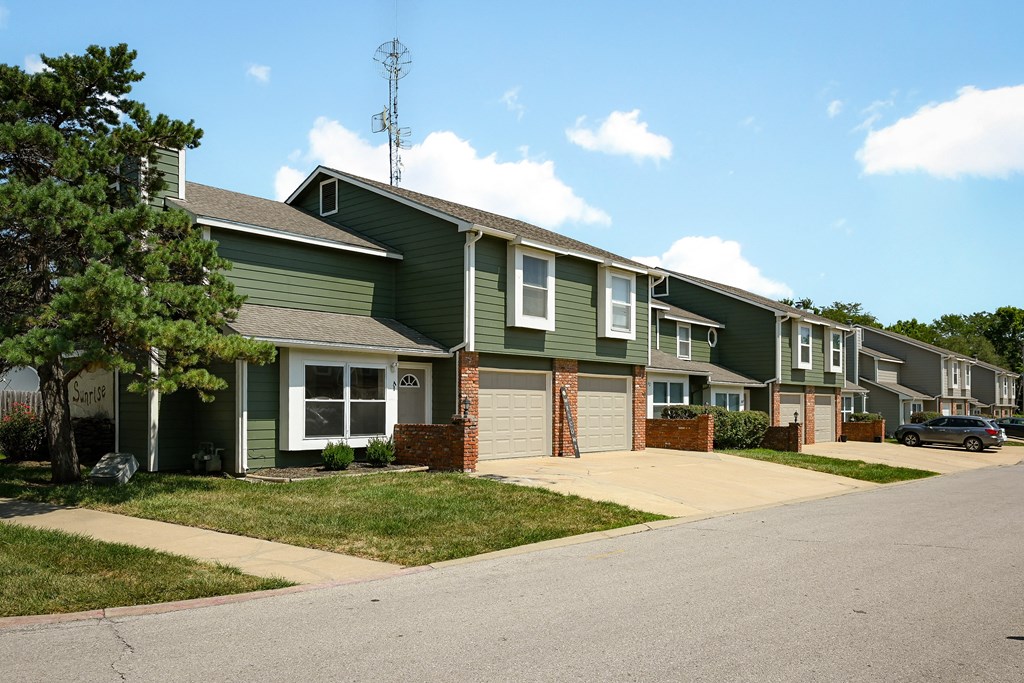 a row of green houses on the side of a street
