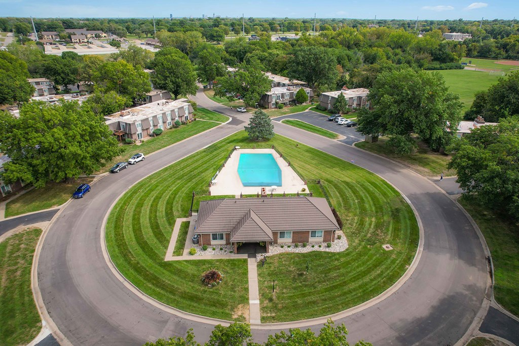 A bird's eye view of an apartment complex's communal space with a swimming pool and other amenities.