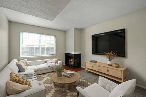 A living room with a fireplace and a television mounted on the wall.