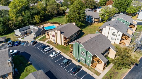 an aerial view of a neighborhood of houses with cars parked on the street