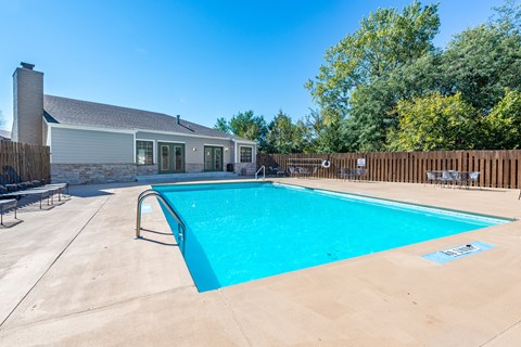 a swimming pool with a house in the background