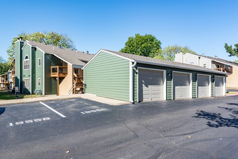 a green building with two garages and a parking lot