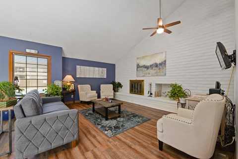 a living room with a couch and chairs and a ceiling fan