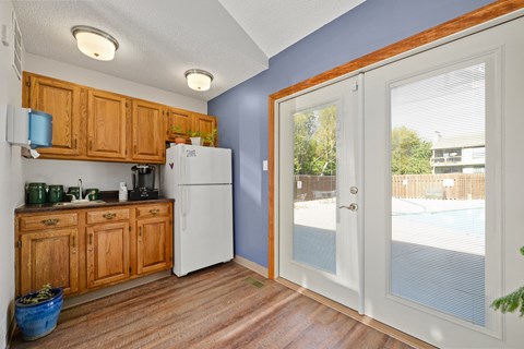 a kitchen with a door to the pool and a refrigerator