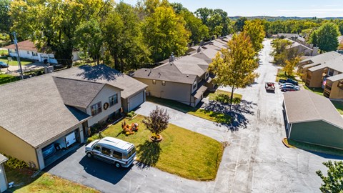 an aerial view of a neighborhood with houses and a van parked in the yard