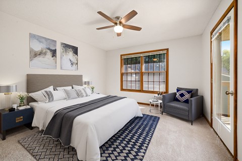 a bedroom with a large bed and a ceiling fan