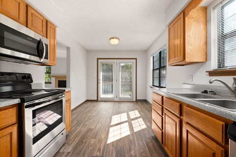 an empty kitchen with wooden cabinets and stainless steel appliances