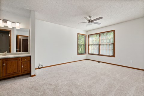 an empty living room with a ceiling fan and a window