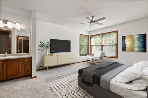 a bedroom with a bed and a ceiling fan and a tv