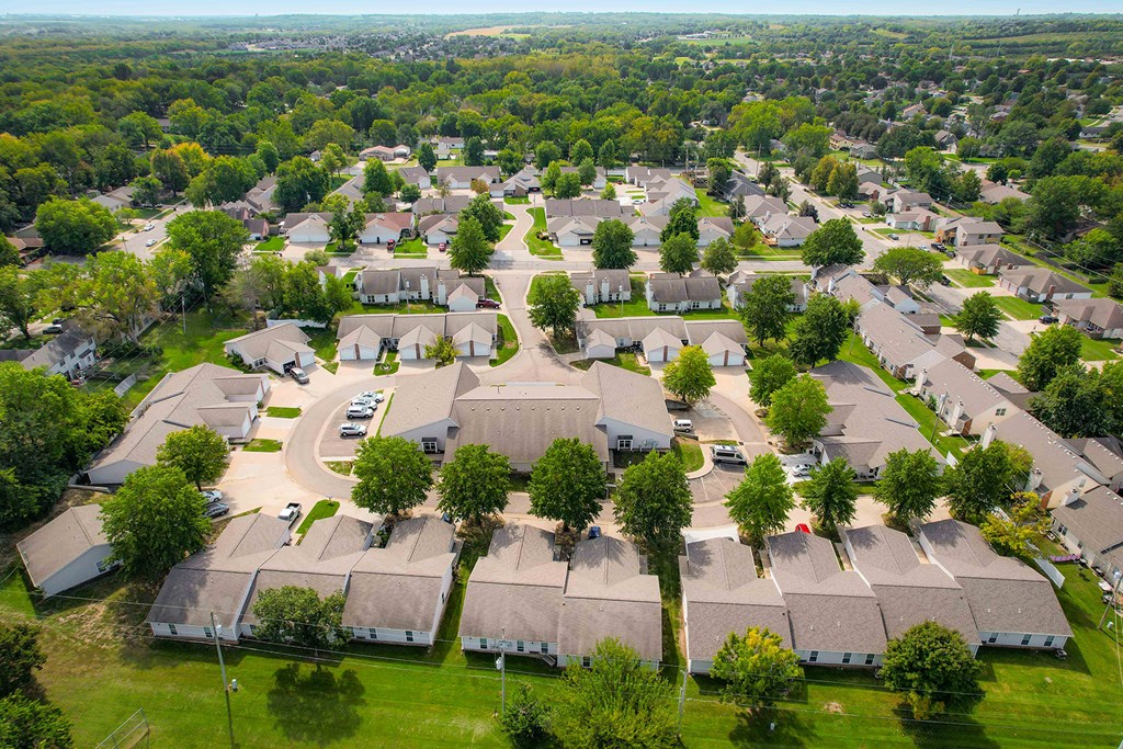 A bird's eye view of a residential area with apartments, duplexes, and trees.