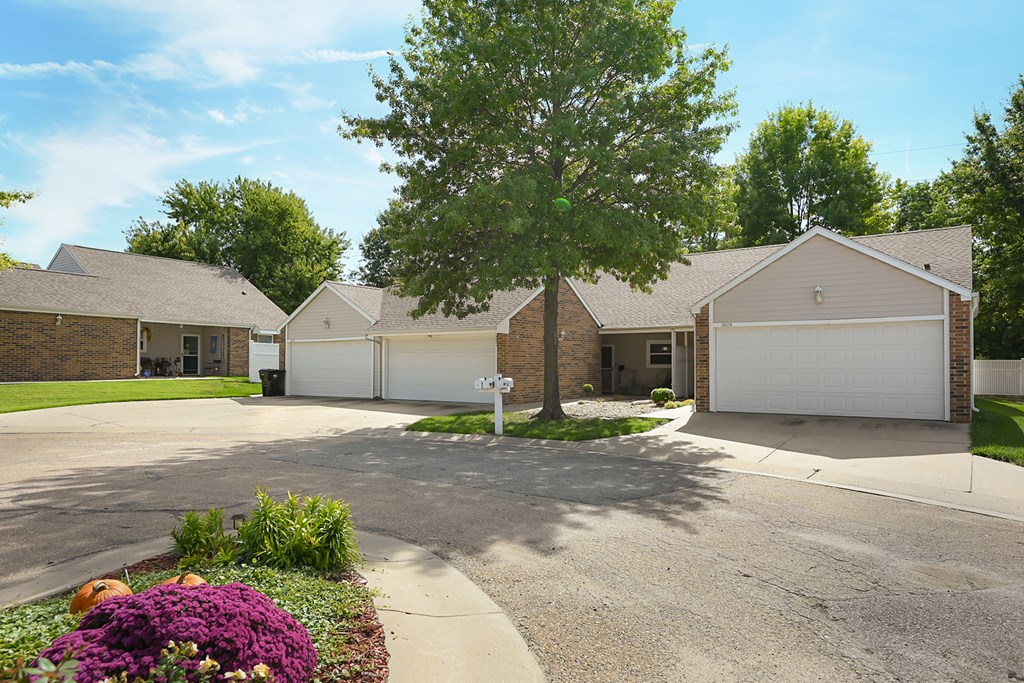 A residential area with houses and a tree in the foreground.