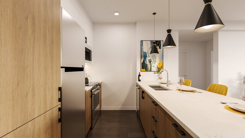 a kitchen with a large counter top and a stainless steel refrigerator