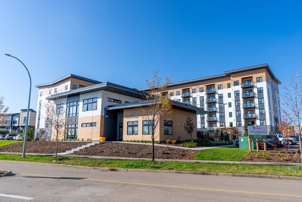 A modern building with a parking lot in front.