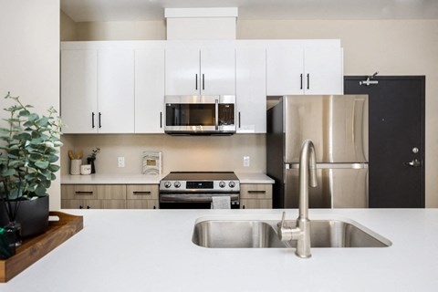 a kitchen with white counter tops and stainless steel appliances