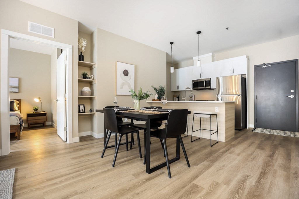 A modern kitchen with a dining table set for two.