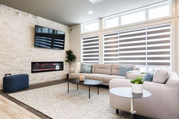 A living room with a fireplace, a sofa, a coffee table, and a television.