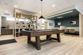 A room with a pool table and a bar area.