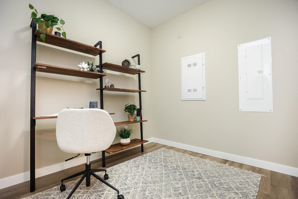 A room with a white chair and shelves with plants on them.