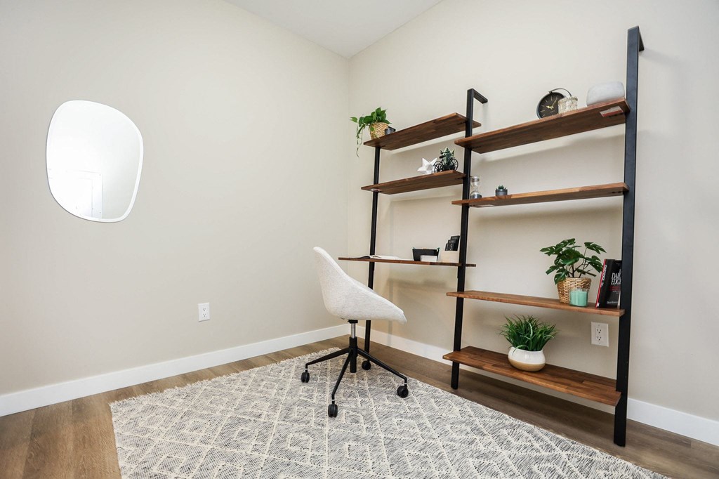 A room with a white chair and a shelf with plants on it.