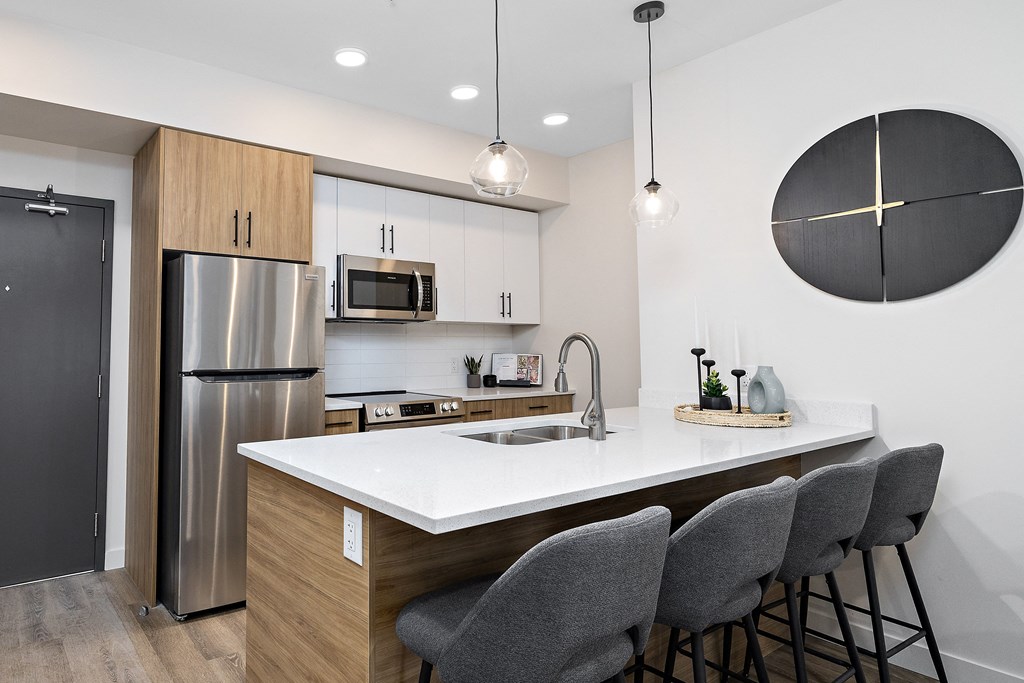 a kitchen with a large island and a stainless steel refrigerator