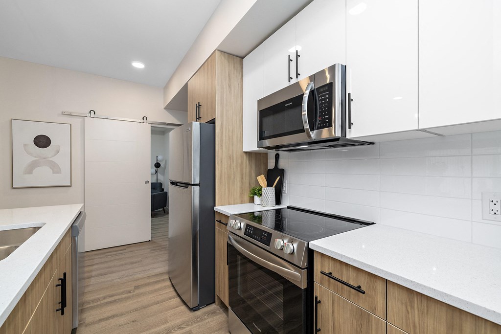 a kitchen with a stove and a microwave at The Fifth at Palisades, Edmonton