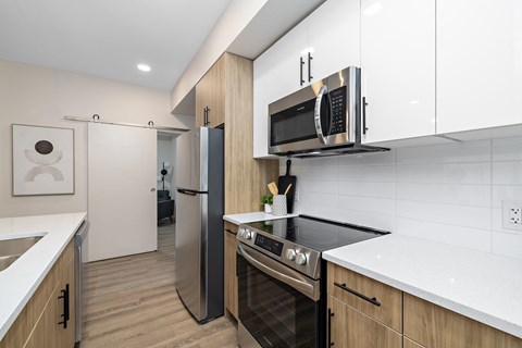 A modern kitchen with a stainless steel refrigerator and oven.