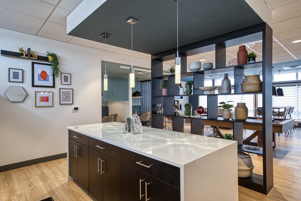 A modern kitchen with a white countertop and dark wood cabinets.