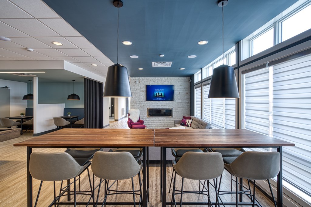 A modern dining room with a wooden table and grey chairs.