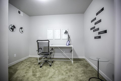 A white desk with a chair and a lamp in a room.