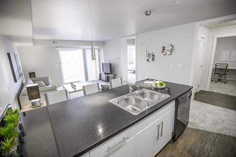 A modern kitchen with a black countertop and white cabinets.