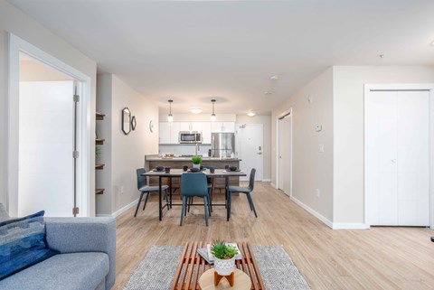 a living room and dining room with a table and chairs