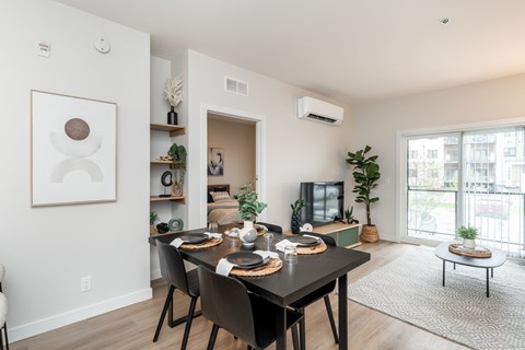 A modern dining room with a black table and chairs.