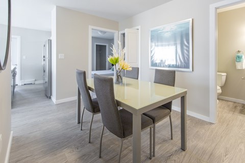 A dining room with a table and chairs.
