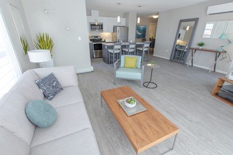 A modern living room with a white couch and a wooden coffee table.