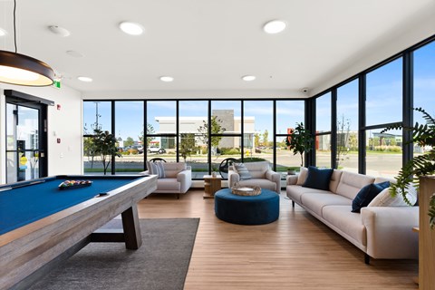 A room with a pool table and a couch.