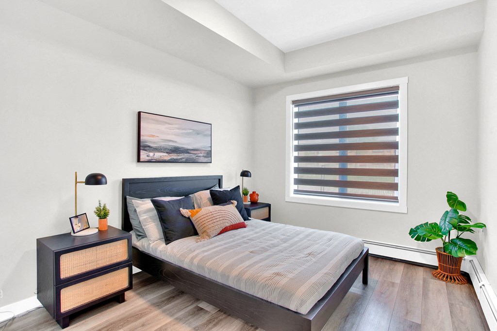 an empty bedroom with a bed and a window