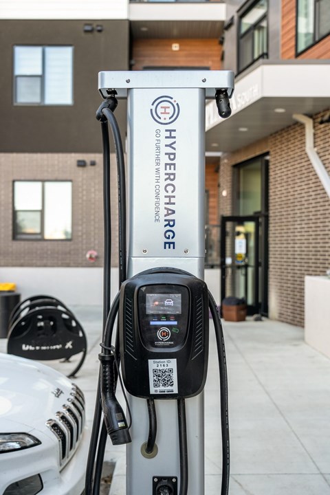 A white car is charging at a Hypercharge station.