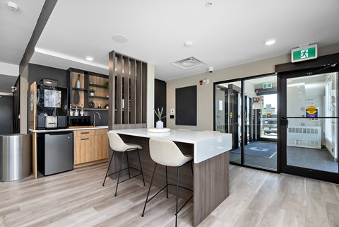 A modern kitchen with a bar area and a dining table.