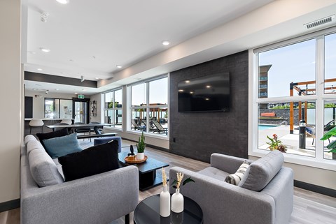 A modern living room with grey couches and a flat screen TV.