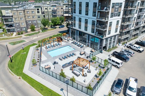 A view of a pool and playground area in a residential complex.
