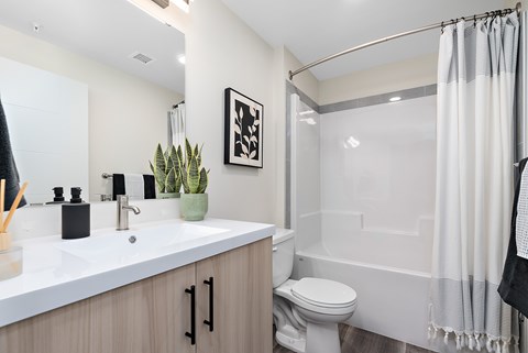 A bathroom with a white sink, toilet, and bathtub.