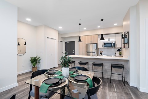 A modern dining room with a glass table and chairs.
