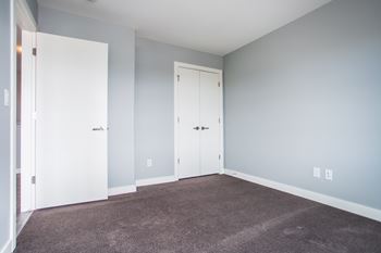 A room with two white doors and a carpeted floor.