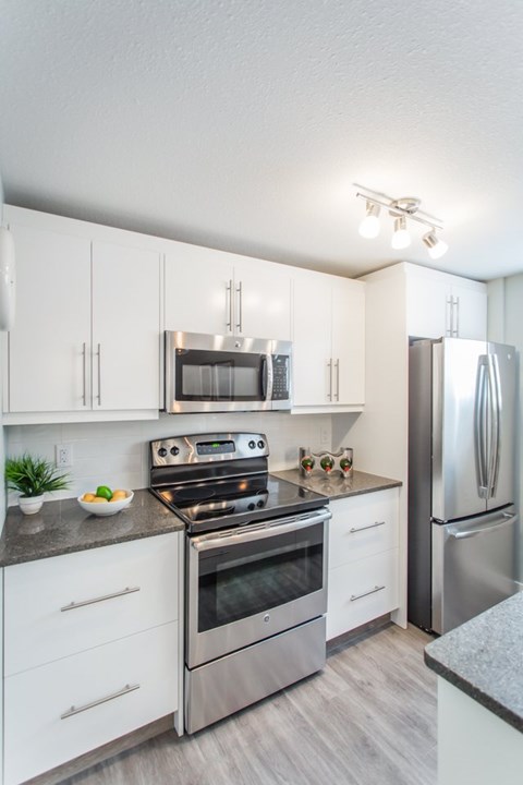 A modern kitchen with stainless steel appliances and white cabinets.