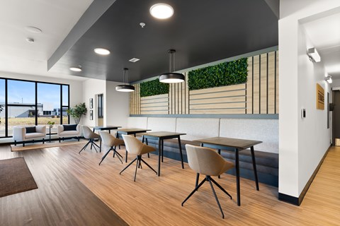 A modern dining area with wooden floors and white walls.