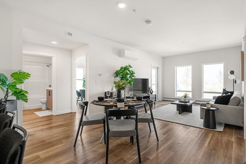 A modern living room with a dining table and chairs.