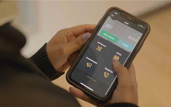 A person holding a phone with a screen displaying a payment app.
