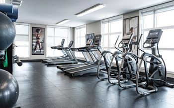 A gym with treadmills and exercise balls.
