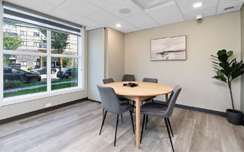 A conference room with a table, chairs, and a plant.